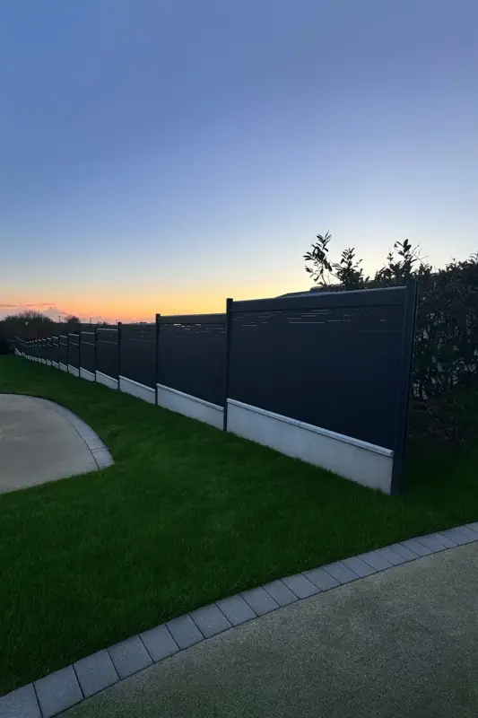 Installation de clôture avec plaques de soubassement en béton pour protéger le grillage